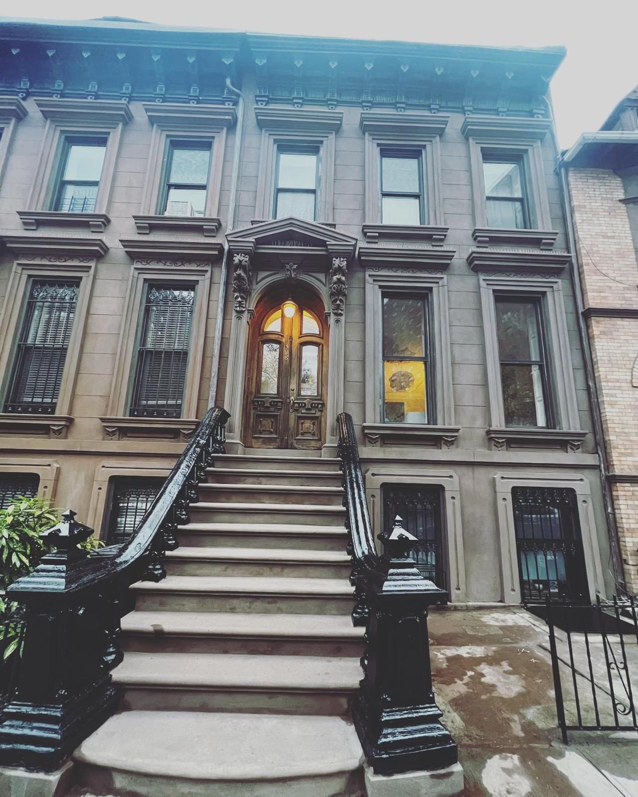 Brooklyn brownstone with restored arched double doors and classical pediment entry