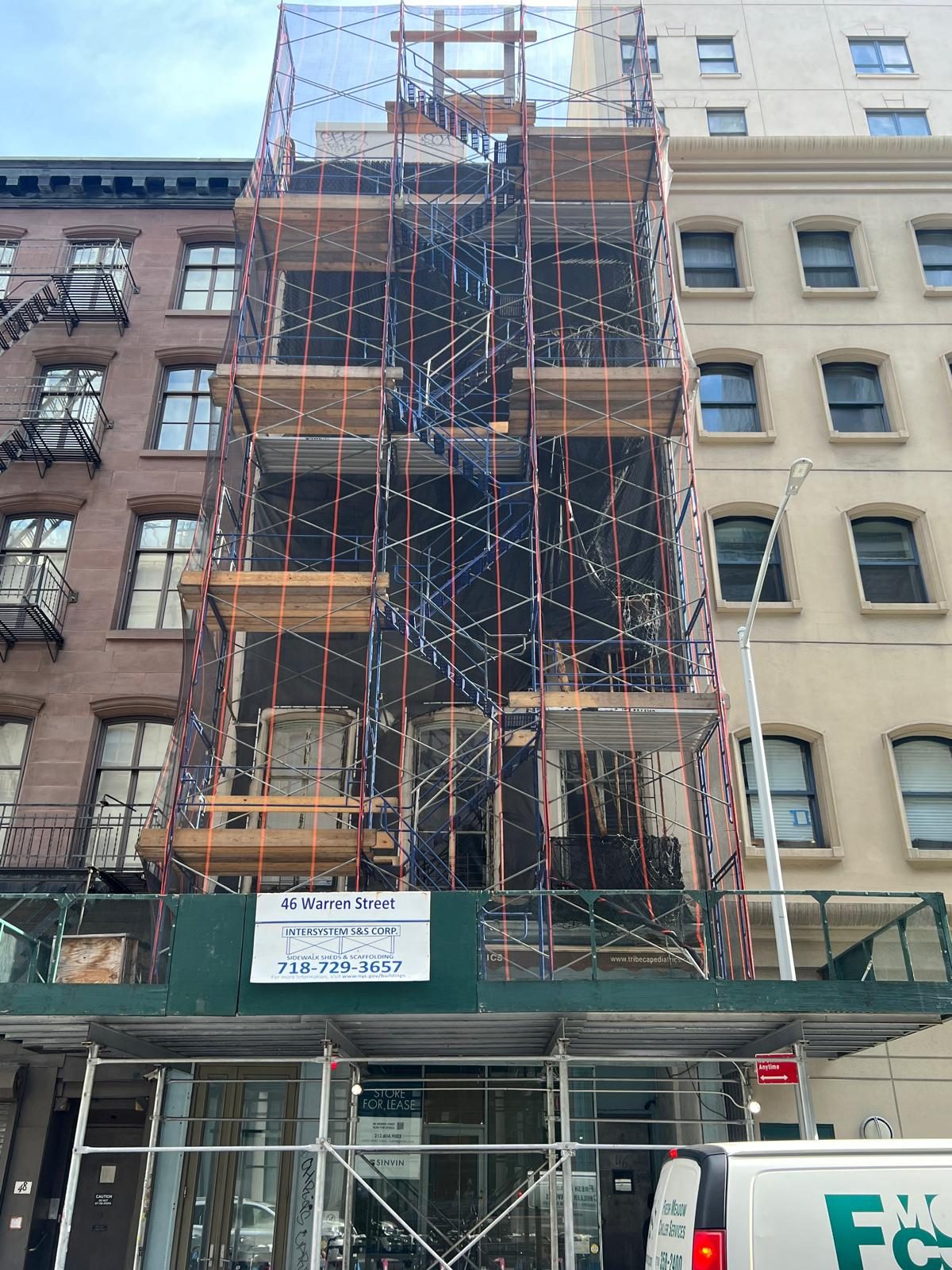 Restored cast iron fire escape and ornamental ironwork on a Brooklyn brownstone façade